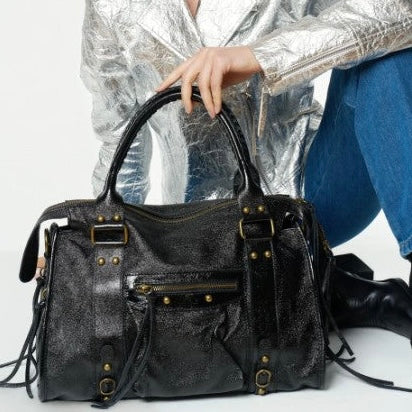 Sac en cuir irisé porté à la main par une mannequin, de couleur noir et de taille L. Peut contenir un ordinateur max 16 pouces.