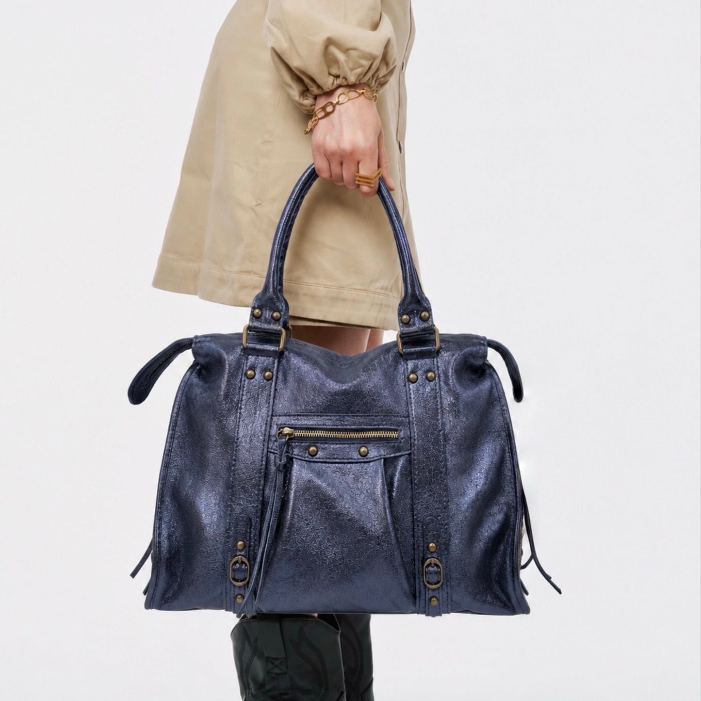 Sac en cuir irisé porté à la main par une mannequin, de couleur bleu marine et de taille L. Peut contenir un ordinateur max 16 pouces.