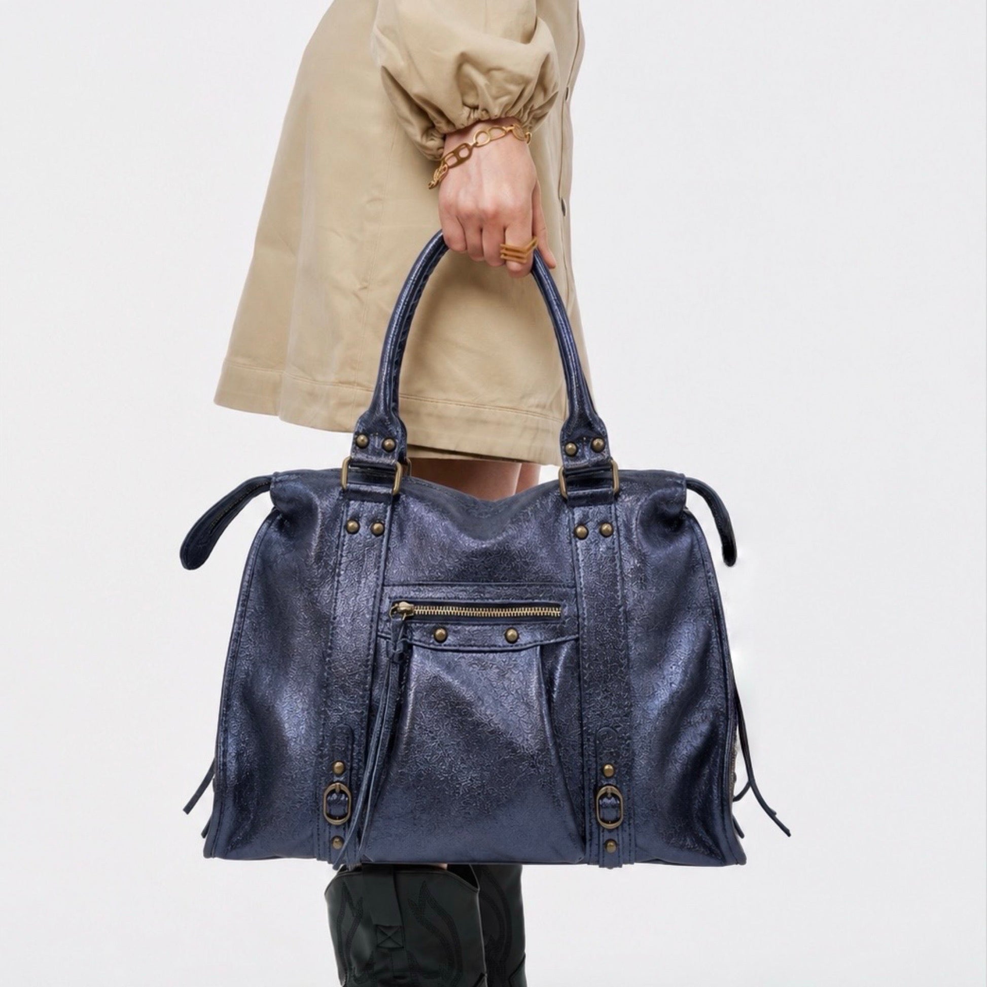 Sac en cuir irisé porté à la main par une mannequin, de couleur bleu marine et de taille L. Peut contenir un ordinateur max 16 pouces.