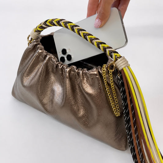 Le sac Plissa (taille M) est un modèle en cuir irisé doté d'un cordon tressé à franges, doublé d'une chaîne en or.
Fabriqué en Italie, ce petit sac séduit par son design unique au fini plissé.

Dimensions : 25 cm x 17 cm x 9.5 cm
Matière : Cuir de vachette irisé
Provenance : Fabriqué en Italie
Porté : Main (avec le cordon), bandoulière ou épaule (avec la chaîne).
Personnalisation : Modulable selon vos envies.
Fermeture : fermeture avec une pression.
Existe également en tailles S et L.